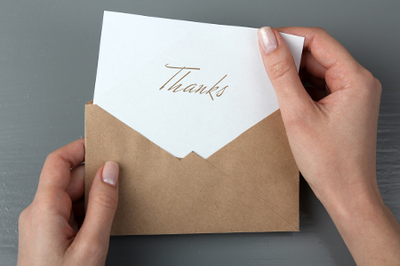 holding a thank you card