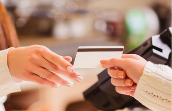 woman handing cashier a credit card
