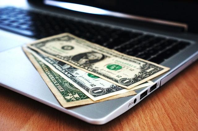 computer with dollars bills on keyboard 