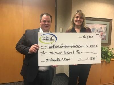 President/CEO Brian Sherrick and EVP of Operations Alisha Johnson hold check representing $10,000 donated to the World Council of Credit Union's Caribbean Hurricane Relief Fund.