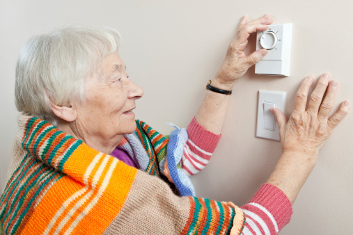 Woman setting thermostat